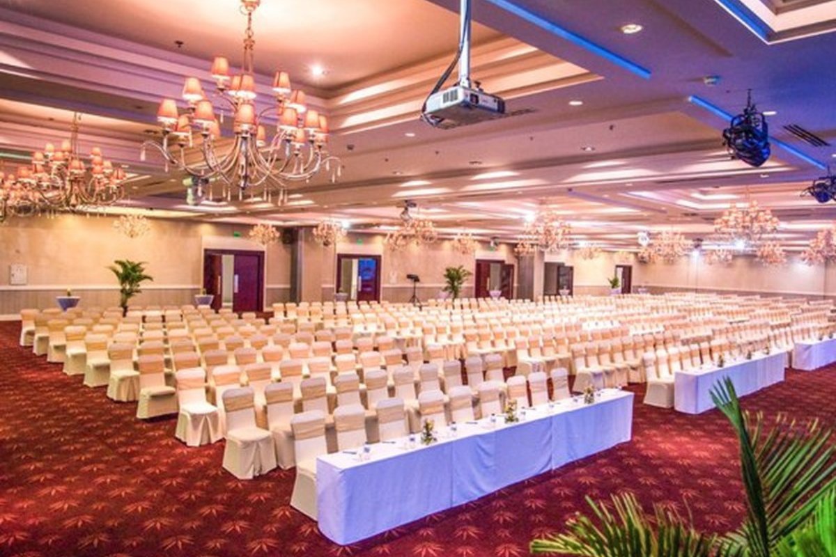 Setup phòng họp báo tone trắng cùng đèn chùm sang trọng